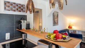 Una cocina moderna con encimera de madera, un tostador empotrado y una cafetera.