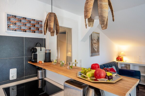 Una cocina moderna con encimera de madera, un tostador empotrado y una cafetera.