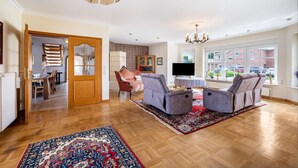 A spacious living room with a fireplace, a television, and a large window with a view of the outside.