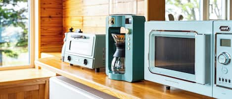 A kitchen with wooden walls, a coffee maker, a toaster, and a microwave.