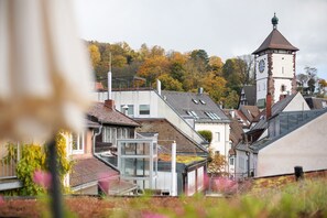 Uma cidade com uma torre do relógio imponente, edifícios modernos e um telhado verde.