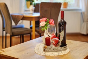 A dining table with a wine bottle, a glass, and a candle.
