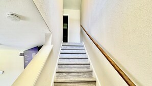 A staircase with wooden steps and white walls.