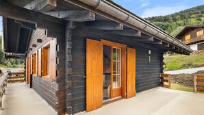 A wooden cabin with large wooden doors and a covered porch. - Eole - 6 pers - près des pistes (Haute-Nendaz)