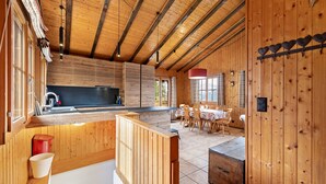 A wooden interior with a kitchen area, dining table, and chairs. - Eole - 6 pers - près des pistes (Haute-Nendaz)