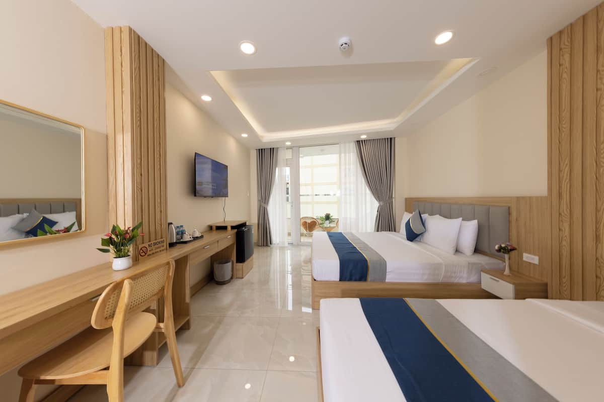 Une chambre d’hôtel avec un bureau en bois, un lit, une télévision et une vue sur l’extérieur.