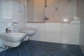 Casa de banho com bidé, sanita e lavatório.