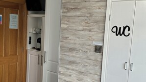 A room with a bed, a wardrobe with 'wc' on it, a wardrobe with a mirror, and a cabinet with a television. - Seacrest B&B (Galway)