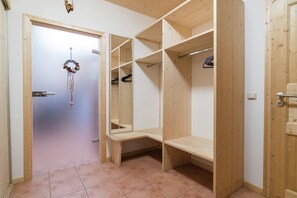 Un armario de madera con repisas abiertas y una puerta decorada con un adorno de guirnalda.