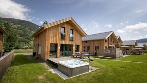 Un hôtel de style chalet en bois, doté d’un bain à remous et d’un espace extérieur aménagé.