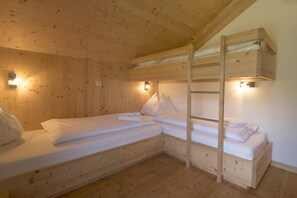 A wooden bunk bed room with two beds, each with white bedding and pillows, and two wall-mounted lights. - Chalet with infrared sauna (Sankt Georgen am Kresichberg)
