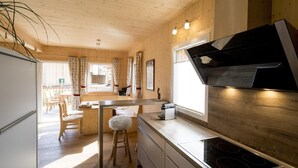 Een moderne keuken met houten wanden, een centraal kookeiland en een inbouwfornuis.