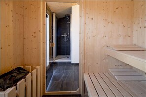 Relax in a serene sauna with a shower area nearby.