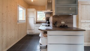 Une cuisine moderne avec des murs en bois, un four encastré et une grande fenêtre.