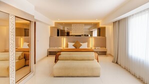 A modern hotel bedroom with a large bed, bedside tables, a mirror, and a view of the outside. - Kuta Angel Hotel (Kuta)