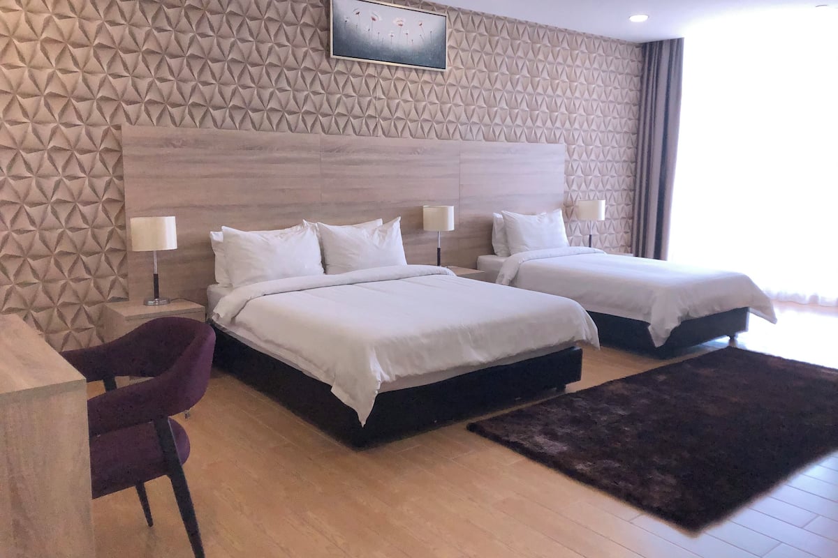 Ein Hotelzimmer mit zwei Betten, einem Schreibtisch und einem Stuhl.