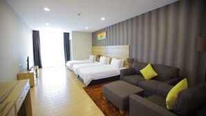 Ein Hotelzimmer mit einem großen Bett, einer Couch, einem Schreibtisch und einem Fernseher.