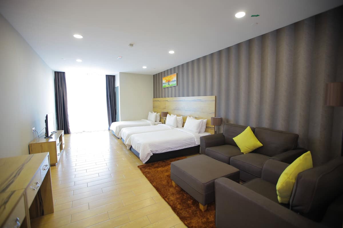 Ein Hotelzimmer mit einem großen Bett, einer Couch, einem Schreibtisch und einem Fernseher.