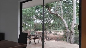 A modern room with a large sliding glass door leading to an outdoor deck.