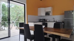 A modern kitchen with white cabinets, a black countertop, and a built-in coffee maker.