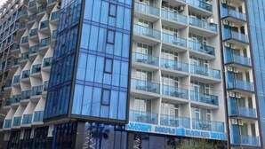 A high-rise hotel with multiple balconies and a modern architectural design.