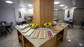 A buffet setup with various food items and a central wooden pillar.