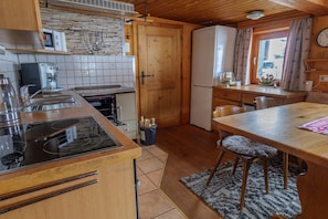 A kitchen with a stove, sink, and wooden cabinets.