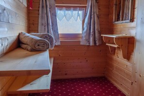 A wooden cabin room with a bench, a window with curtains, and a red patterned carpet. - Chalet near Passthurn Ski Area Kitzbühel (Mittersill)
