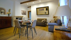 Un coin repas avec une table dressée pour quatre personnes, un canapé et une lampe.
