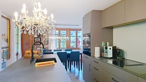 Een moderne keuken met een kroonluchter, een eethoek en uitzicht op de omgeving.