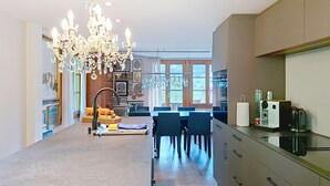 Een moderne keuken met een eethoek, een kroonluchter en een uitzicht door grote ramen.