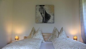 Una cama doble con cabecera, dos lámparas de noche y un cuadro en la pared.