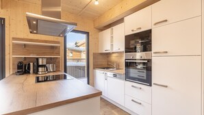 Eine moderne Küche mit weißen Schränken, Edelstahlgeräten und einer Holz Arbeitsplatte.