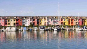 A row of colorful, multi-story buildings with a marina in front.