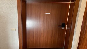 Een houten deur met een sleutelgat en een klein label.