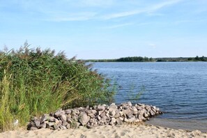 A calm lake with a rocky shoreline and dense vegetation. - Studio Wohnung, mit Grill Platz im Hof (Eilenburg)