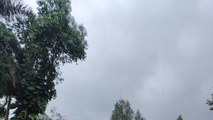Ein zweistöckiges Haus mit rotem Dach, Backsteinfassade und kleiner Veranda.