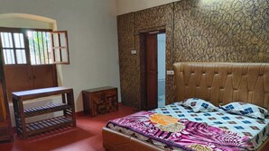 Ein Schlafzimmer mit einem Bett, einer Holzbank und einem kleinen Tisch.
