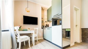 Una cocina moderna con un televisor de pantalla plana, una mesa de comedor con sillas y una chimenea.