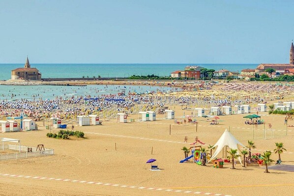 Une plage bondée, avec de nombreux parasols et beaucoup de vacanciers.
