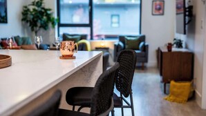 A modern kitchen with a marble countertop, a copper mug, and a wicker chair.