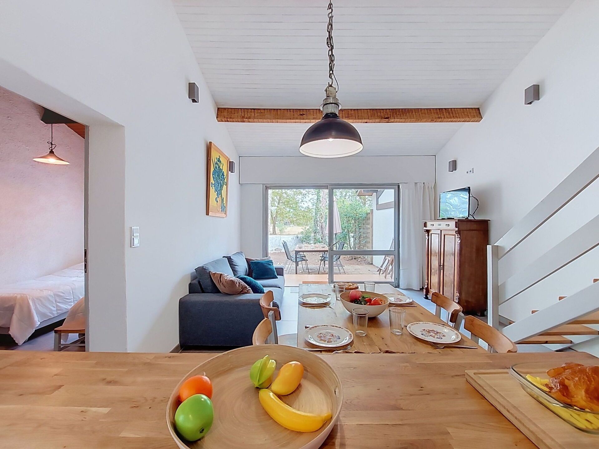 Eine moderne Küche mit Essbereich, einer Couch und einem Fernseher.