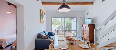 Une cuisine moderne avec un coin repas, un canapé et un téléviseur.