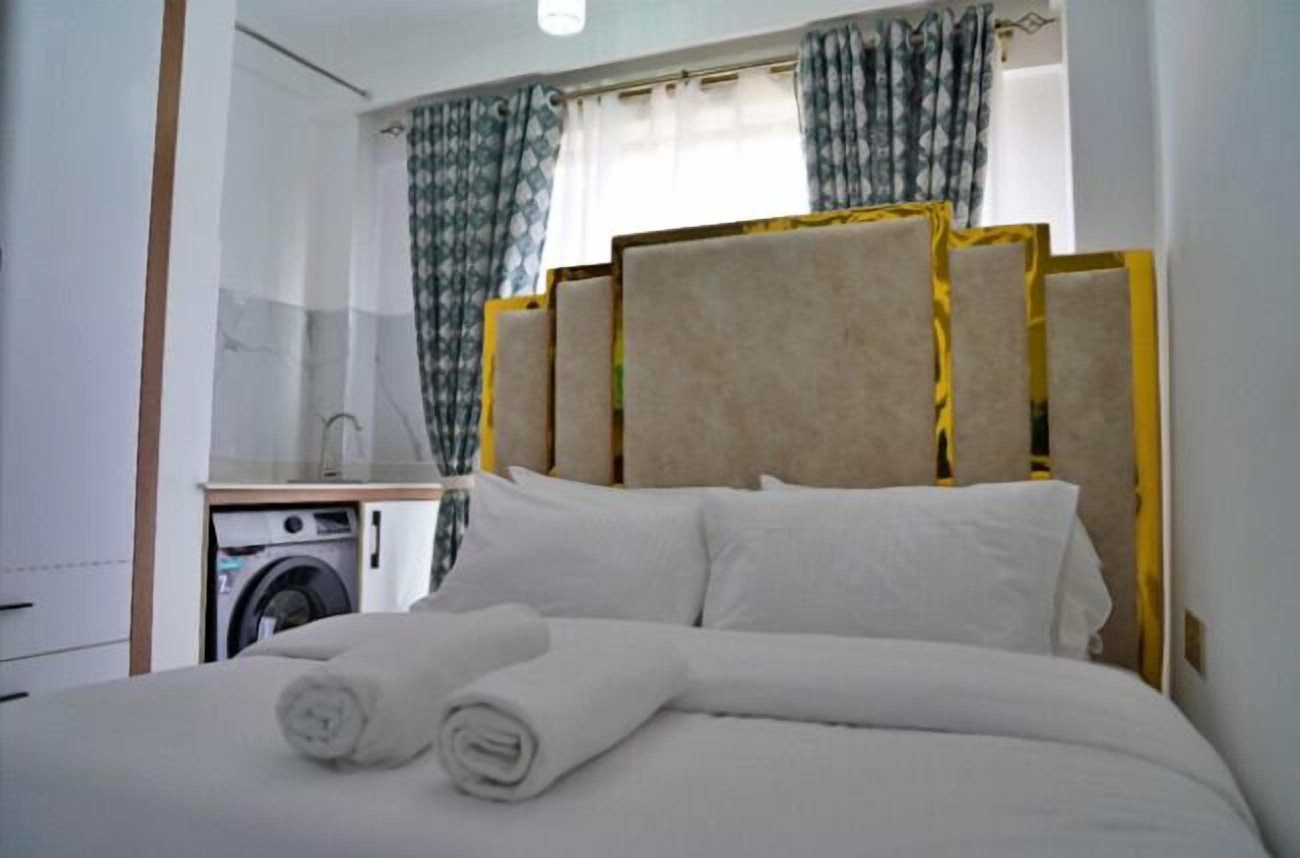 Ein Hotelzimmer mit einem Bett, einer Waschmaschine und Vorhängen.
