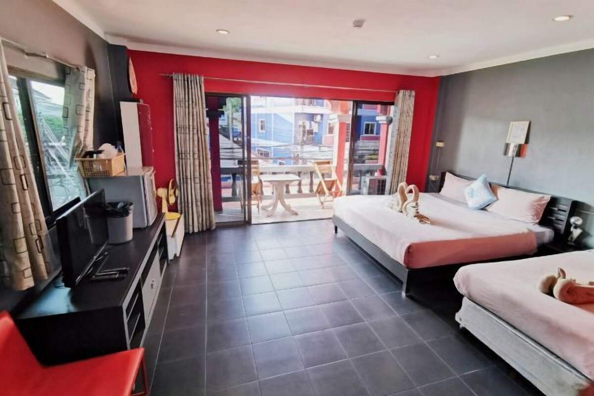 A hotel room with a bed, a desk, a chair, and a TV.