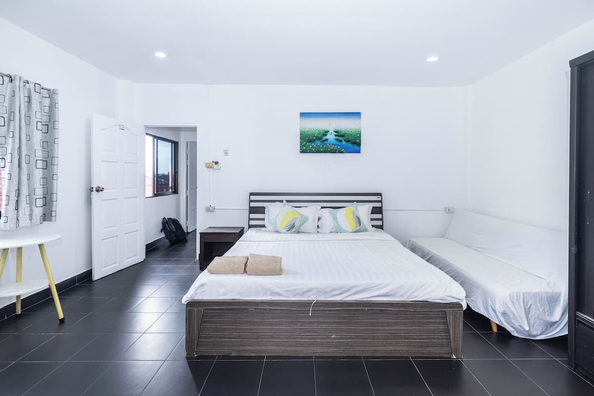 Un dormitorio moderno con una cama grande, una mesita pequeña y un cuadro en la pared.