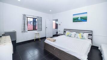 Une chambre à coucher avec un lit, une table de chevet, une fenêtre avec des rideaux, une porte et un tableau au mur.