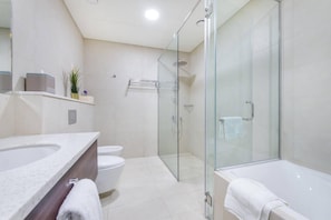 A modern bathroom with a glass-enclosed shower, a bathtub, and a toilet. - GLOBALSTAY. Avani Palm View (Dubai)