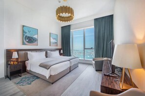 A modern hotel room with a large bed, a desk, a chair, and a view of the city. - GLOBALSTAY. Avani Palm View (Dubai)