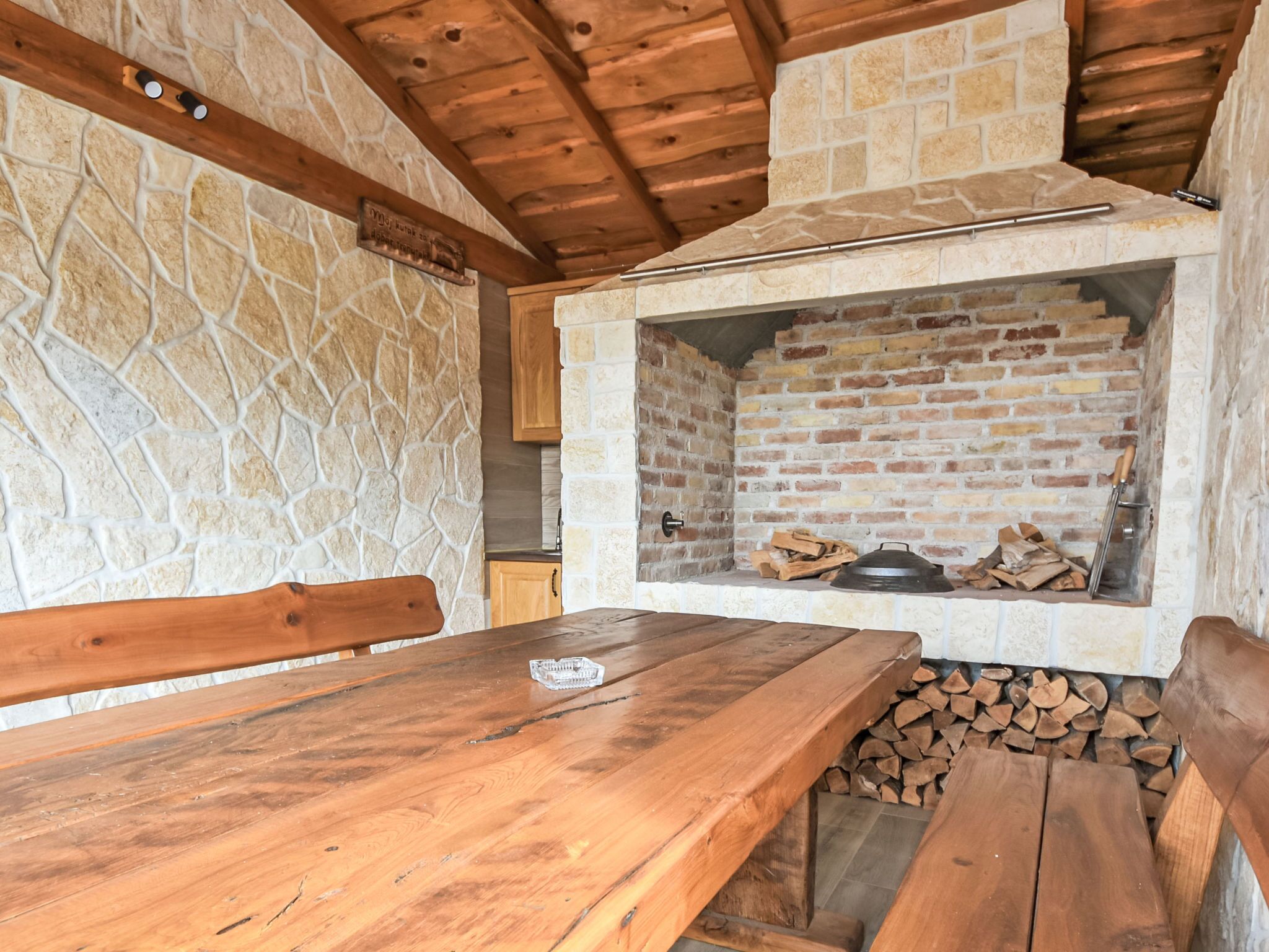 Un mur de pierres rustiques, avec un banc en bois et une table devant.